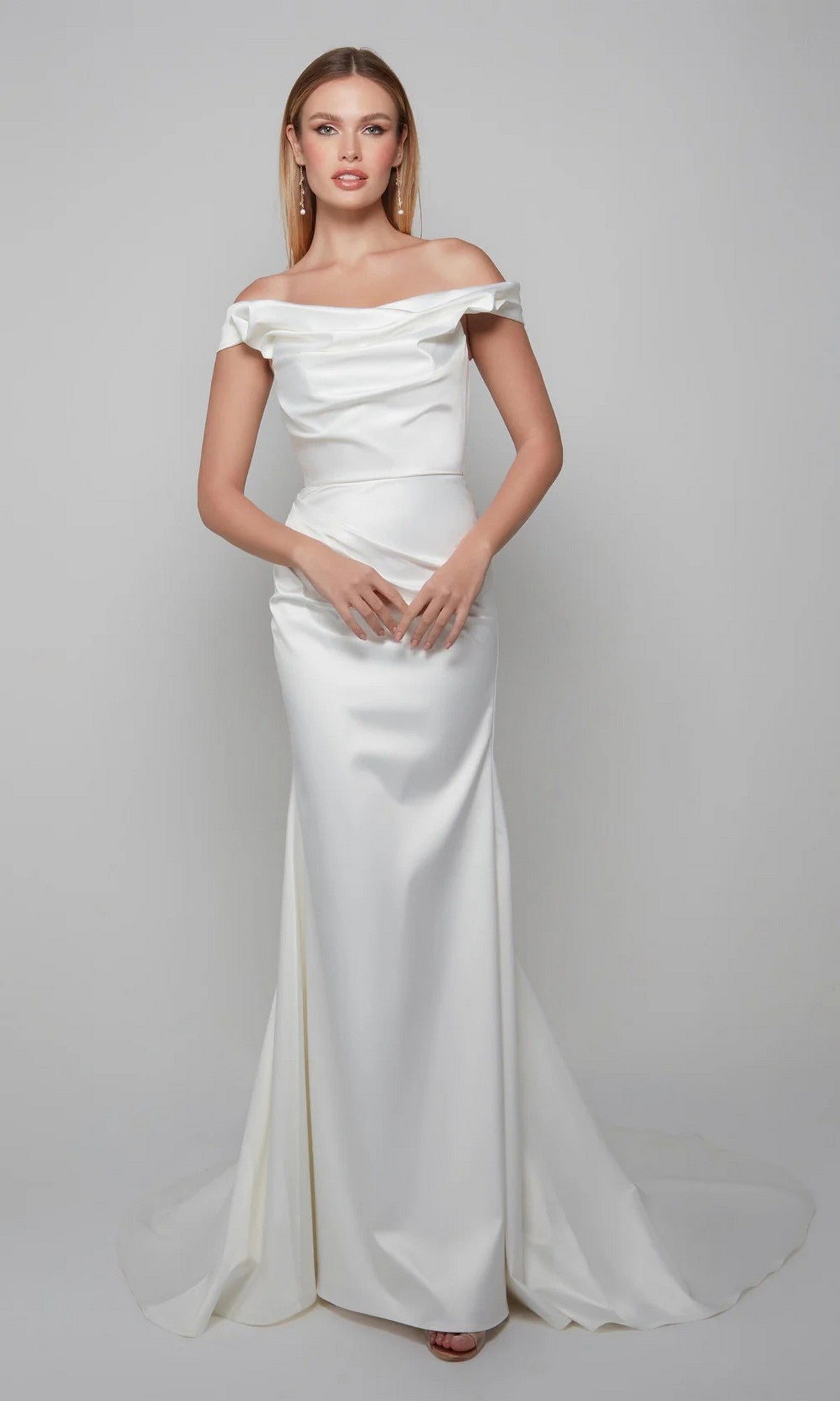 A woman faces forward in the Alyce 7064, a long white off-the-shoulder satin dress with a fitted bodice and floor-length skirt, set against a plain gray background.